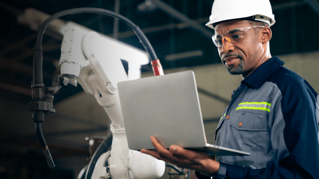 Engineer working with laptop wearing a hard hat