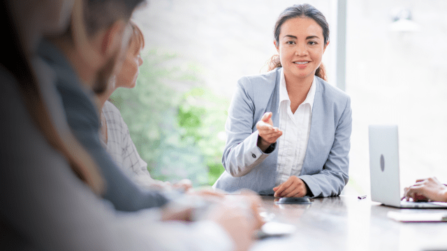 Manager sitting down with team around table