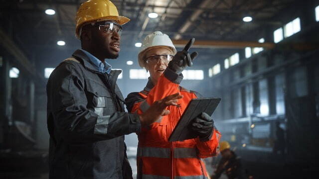 Two people walking through manufacturing warehouse