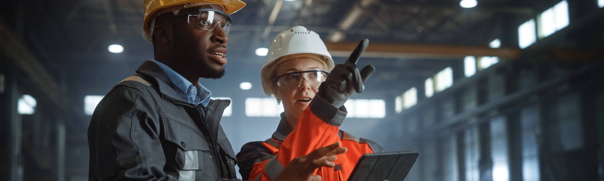 Two people walking through manufacturing warehouse