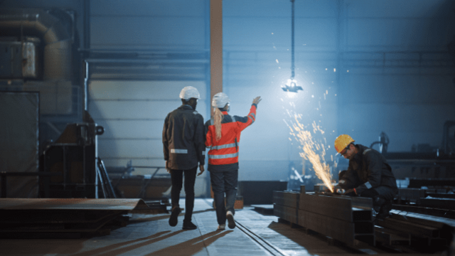 Two people walking through manufacturing warehouse