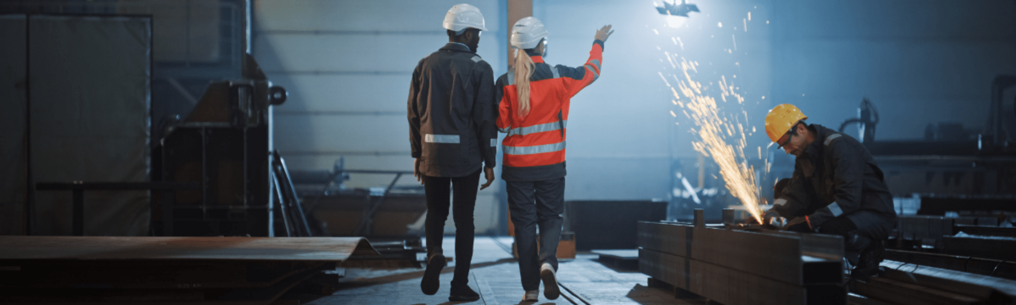 Two people walking through manufacturing warehouse