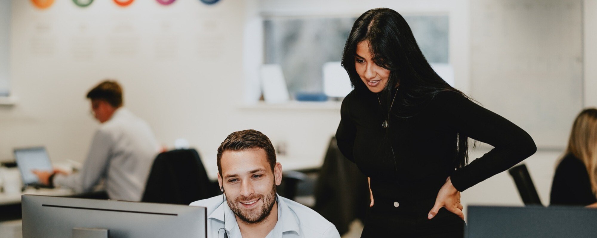 two people looking over a computer